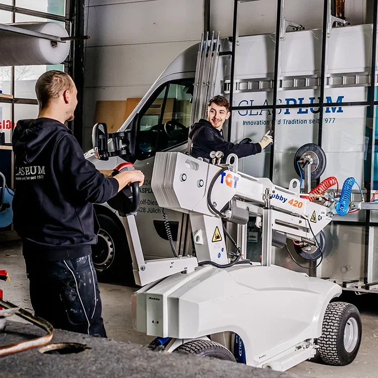 Zwei Mitarbeiter des Glasmeisterbetriebs Glas Plum arbeiten mit dem Kranservice